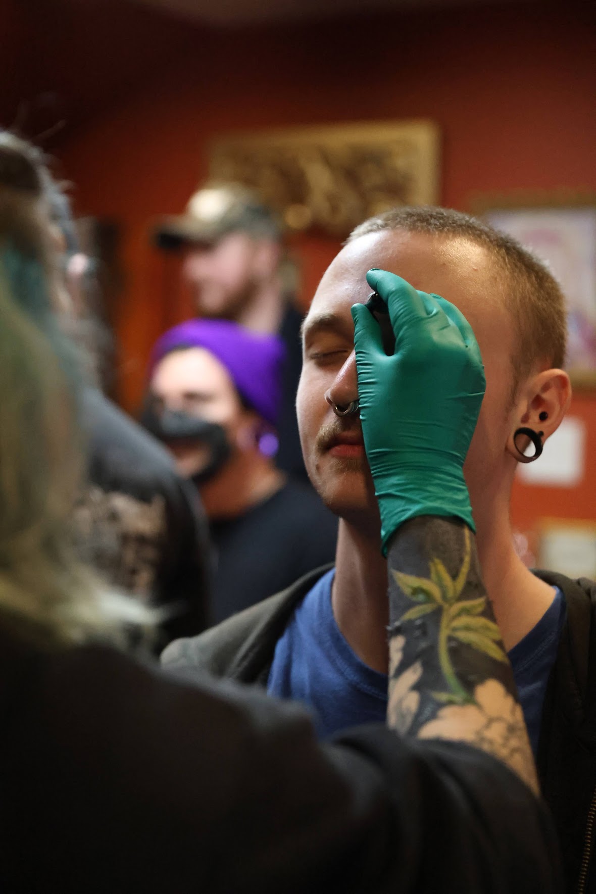 Piercer Casey marks client for a forehead surface anchor